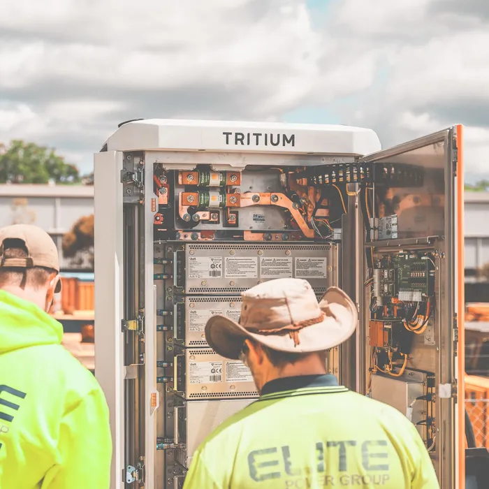 Techniciens installant un coffret de borne de recharge rapide