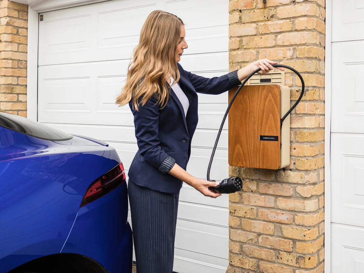 Borne de recharge murale chargeant un véhicule électrique sur une allée de maison